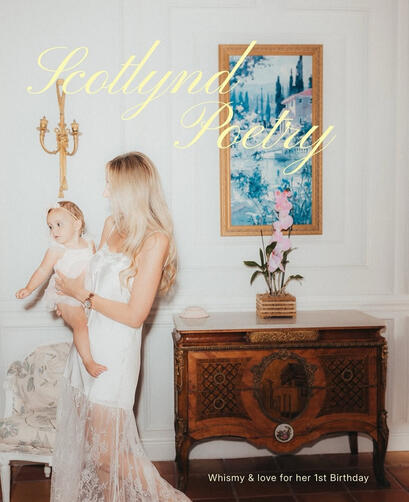 VISUAL POETRY // Curated antique furnishings and museum-grade textures acting as fine-art heirloom portrait frames. Editorial portrait of a mother holding her baby daughter next to a vintage French marquetry commode chest and a gold-framed painting in a sun-drenched luxury studio venue.